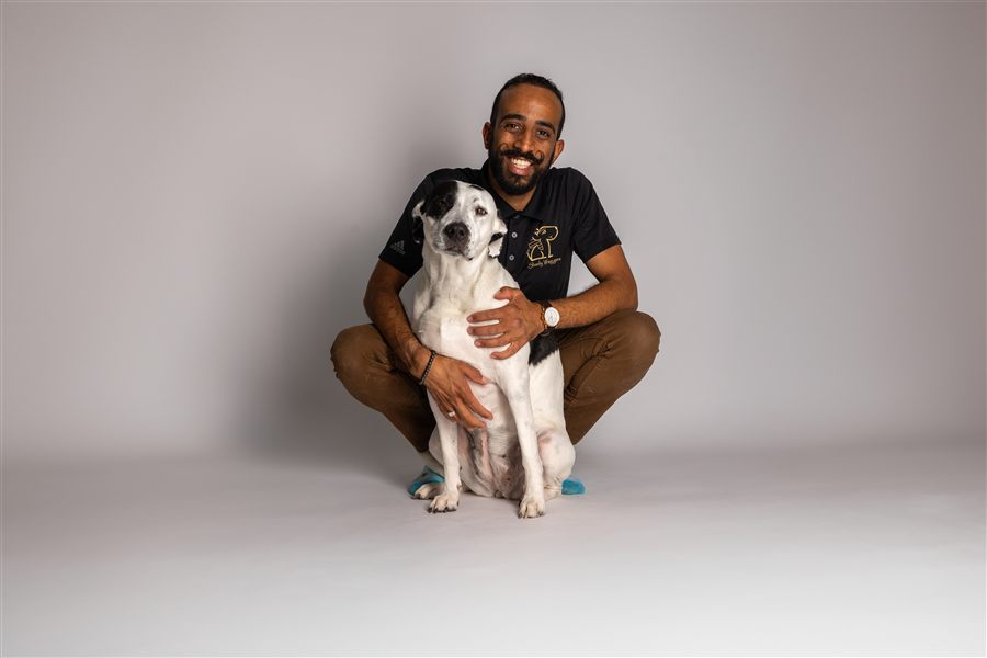Shady, founder of Shady Waggers, hugging his dog Moo